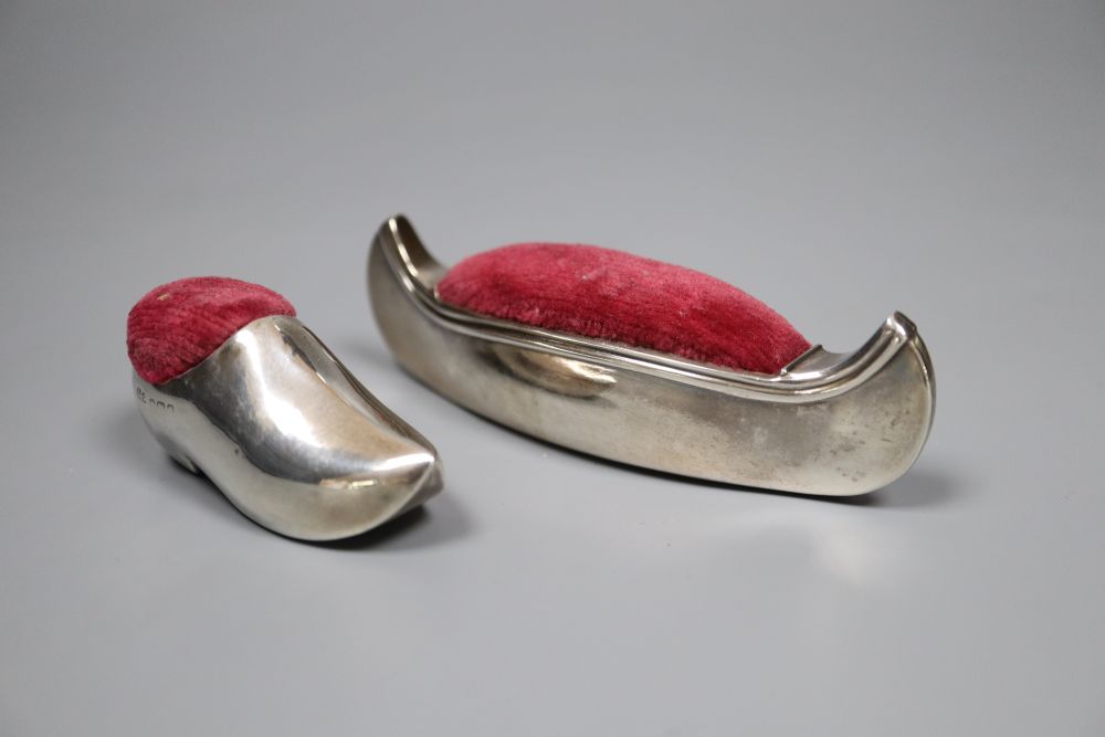 Two early 20th century novelty silver mounted pin cushions, canoe & clog, marks rubbed, canoe 9.5cm.